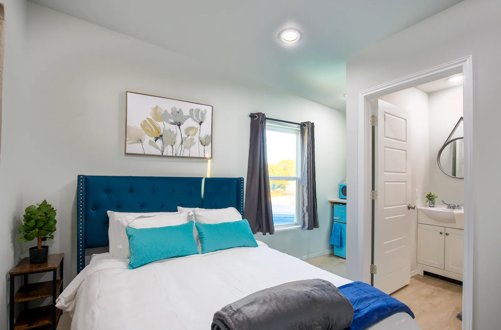 Furnished bedroom with a tufted headboard and ensuite bathroom in a container home